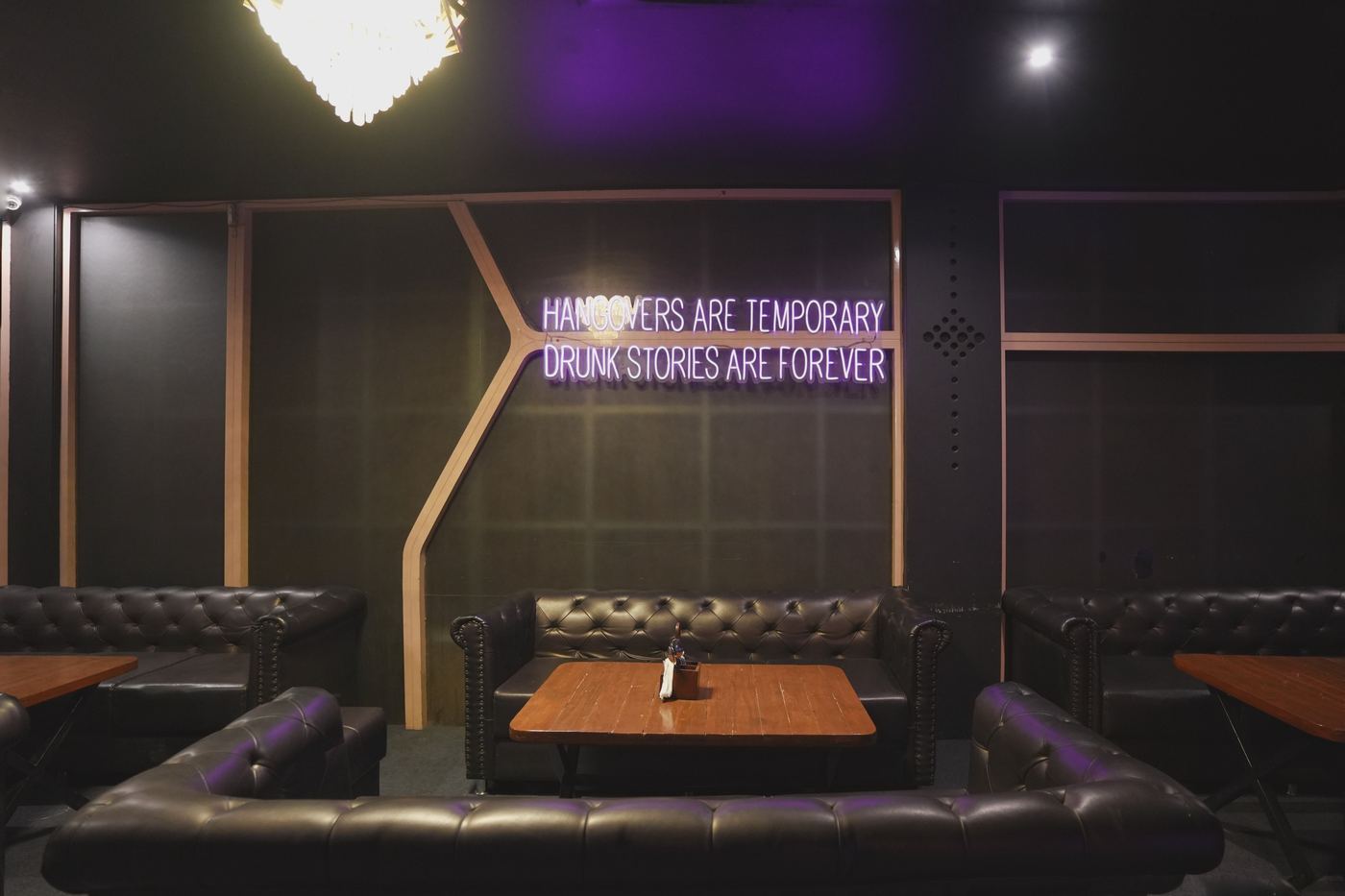 The lounge at Ellara, with Chesterfield sofas and neon